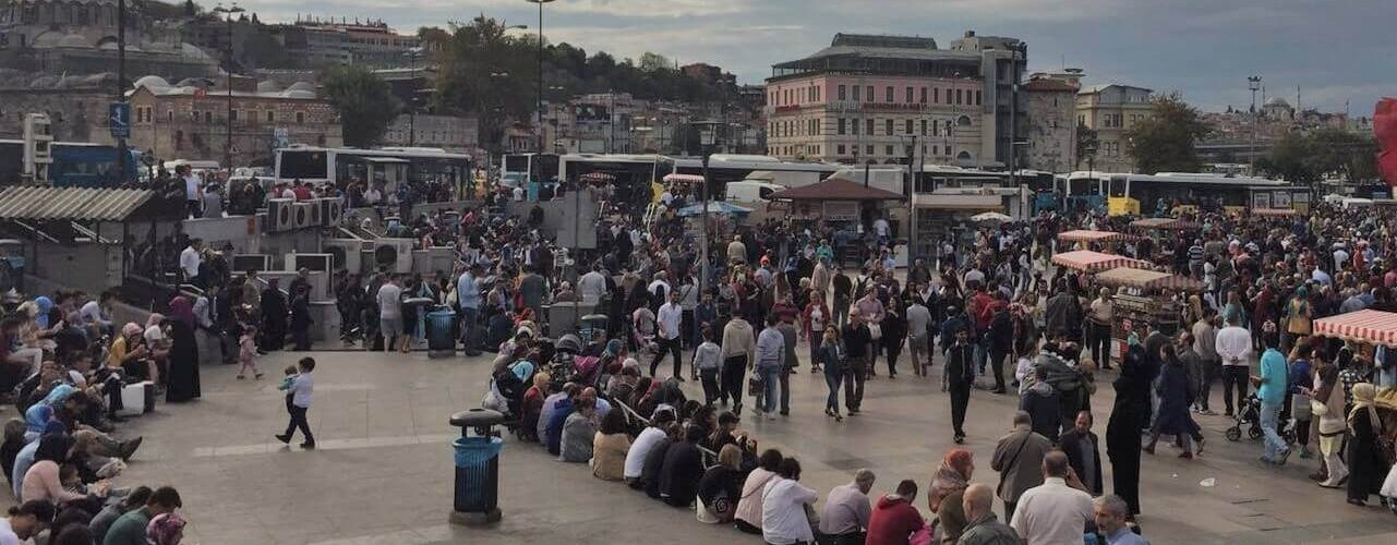 people in eminono in turkey sitting around the square